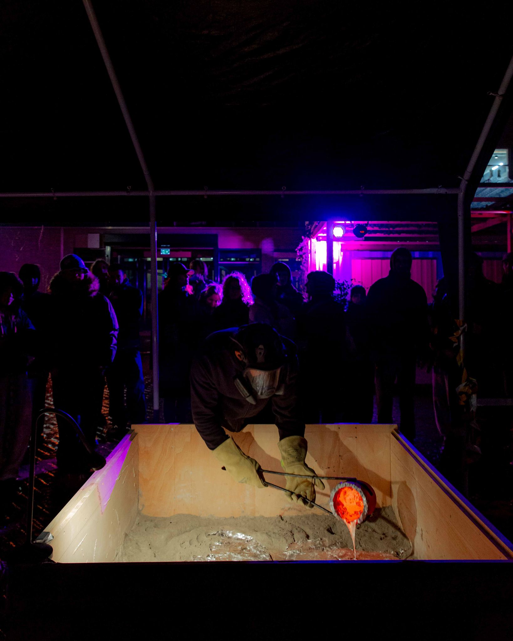 Casting event — pouring aluminium into sand moulds
